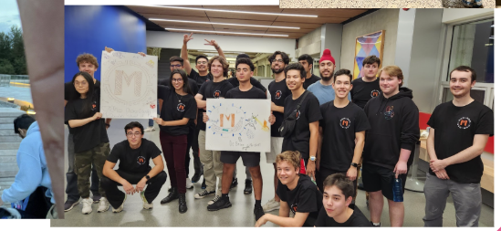 A large group of students in matching black t-shirts holding up signs