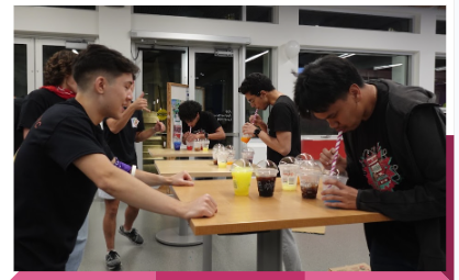 Students gathered around a table making drinks together