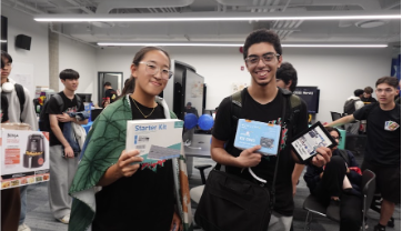 Two students holding starter kit boxes at a past ESSS event