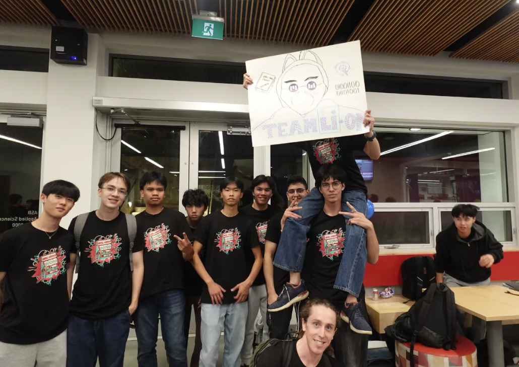 Students posing together with a sign