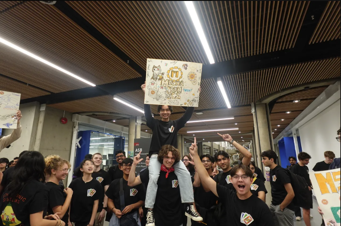 Students celebrating with a handmade engineering sign